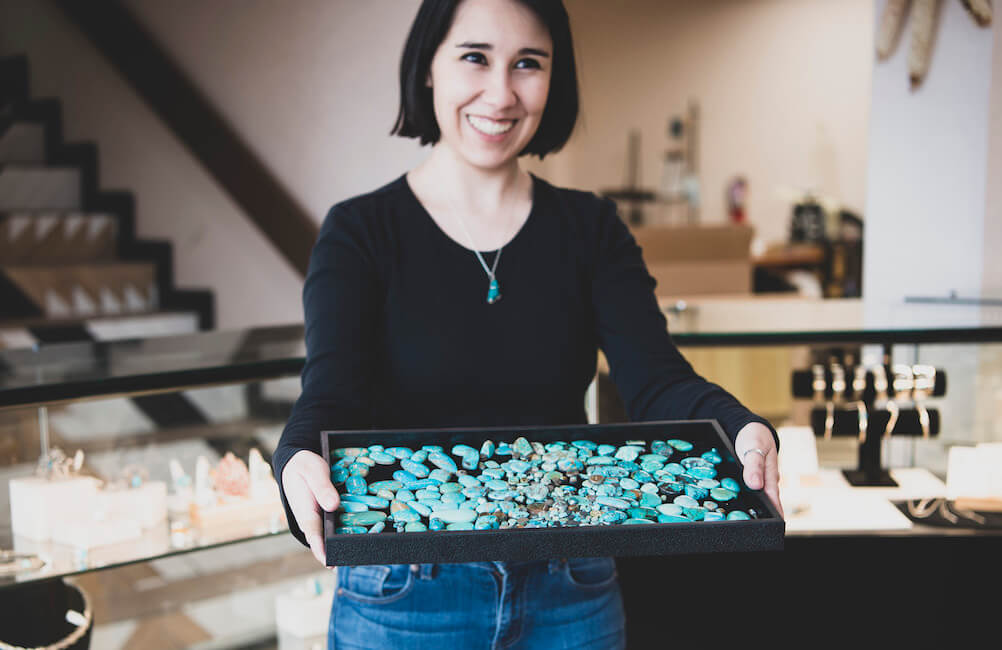 A tray of natural turquoise presented in the gallery — honest materials, shown in the open